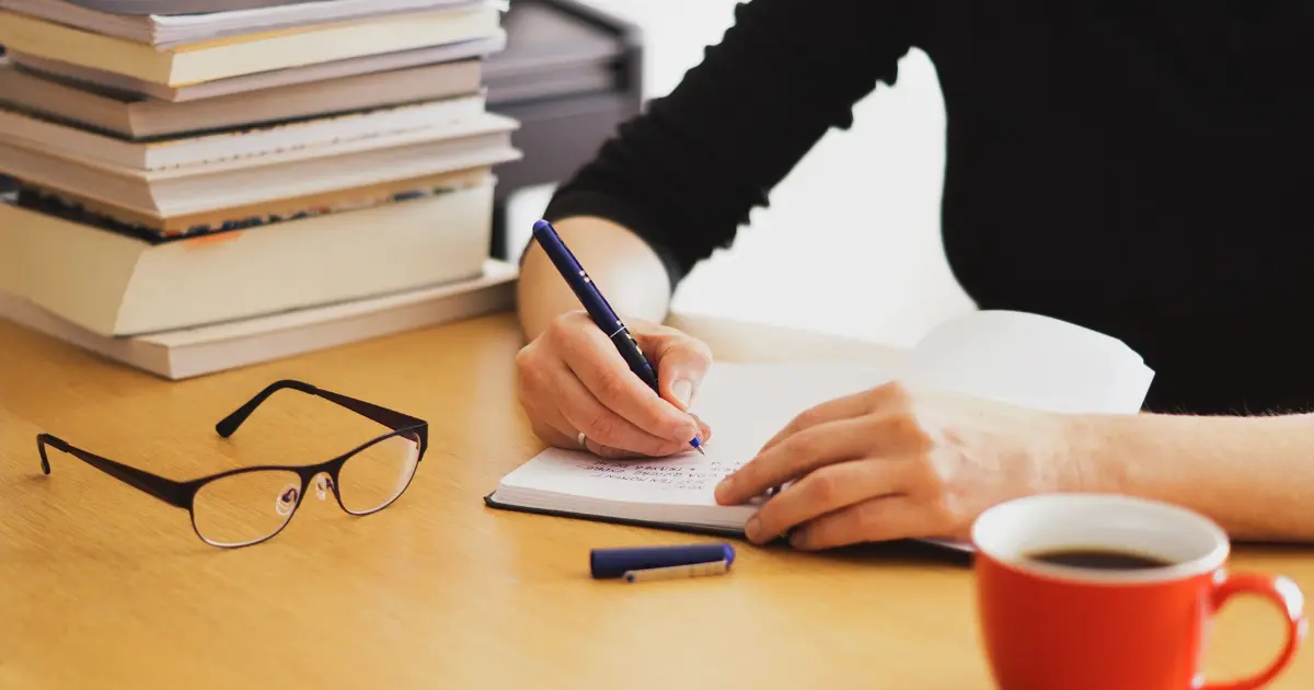 a women Writing a Research Paper on a desk